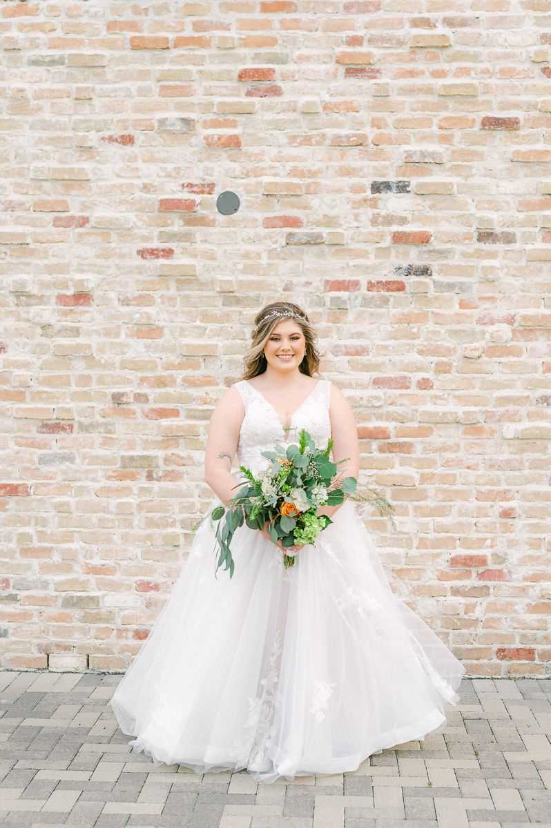 bride in front of brick wall
