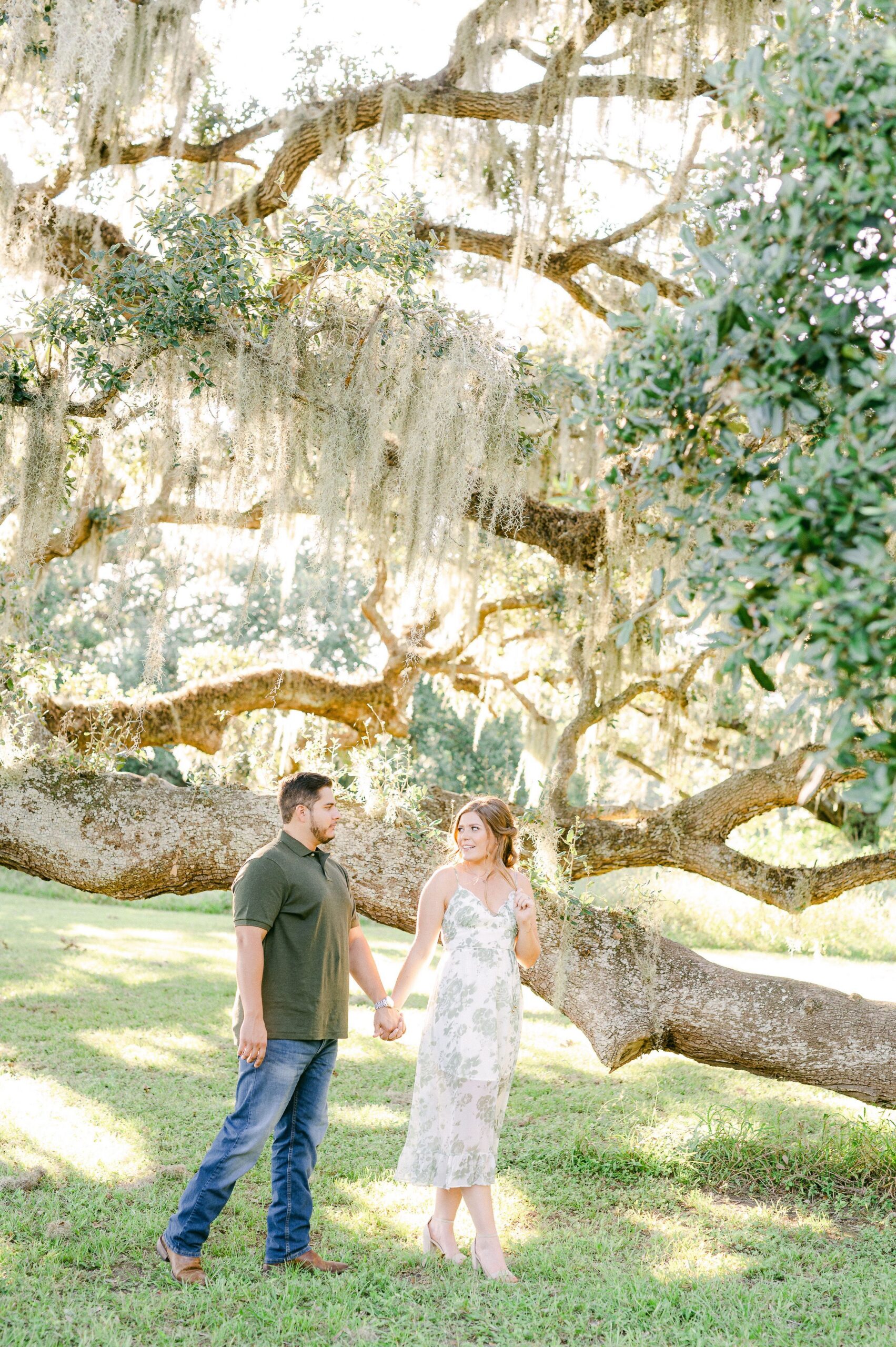 couple at engagement session under Spanish Moss tree