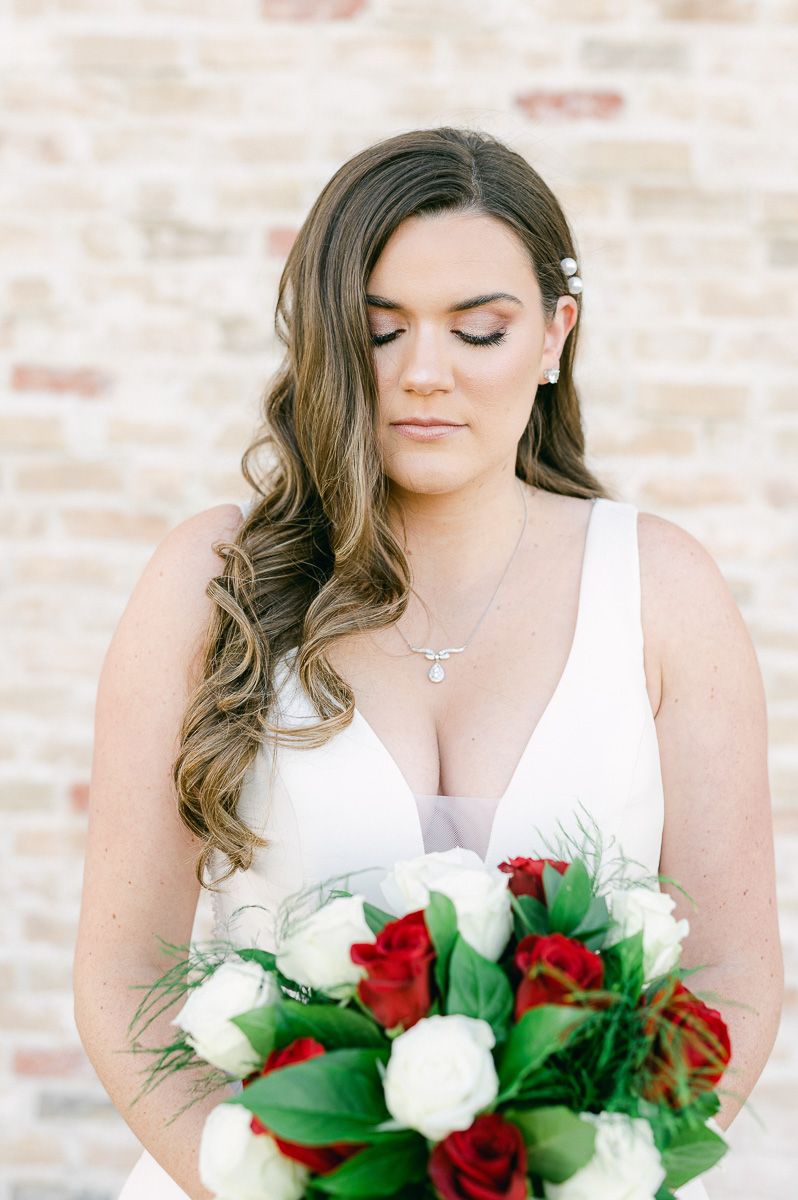 bride with red and white rose bouquet