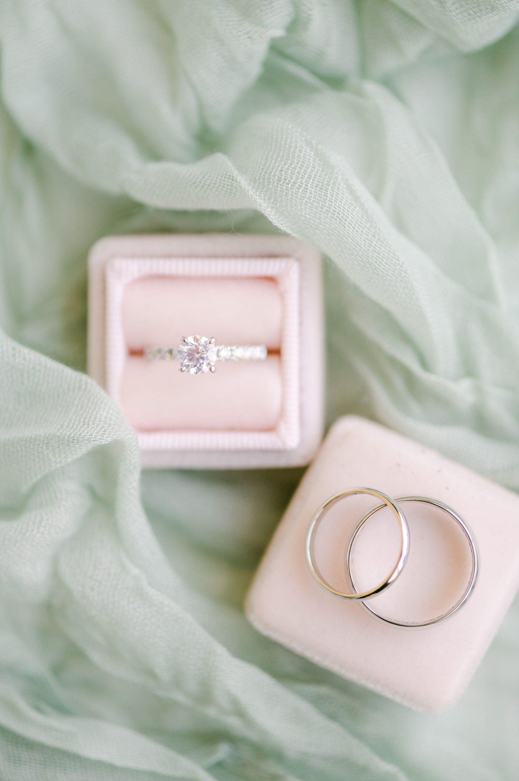 wedding rings in pink box on mint green fabric