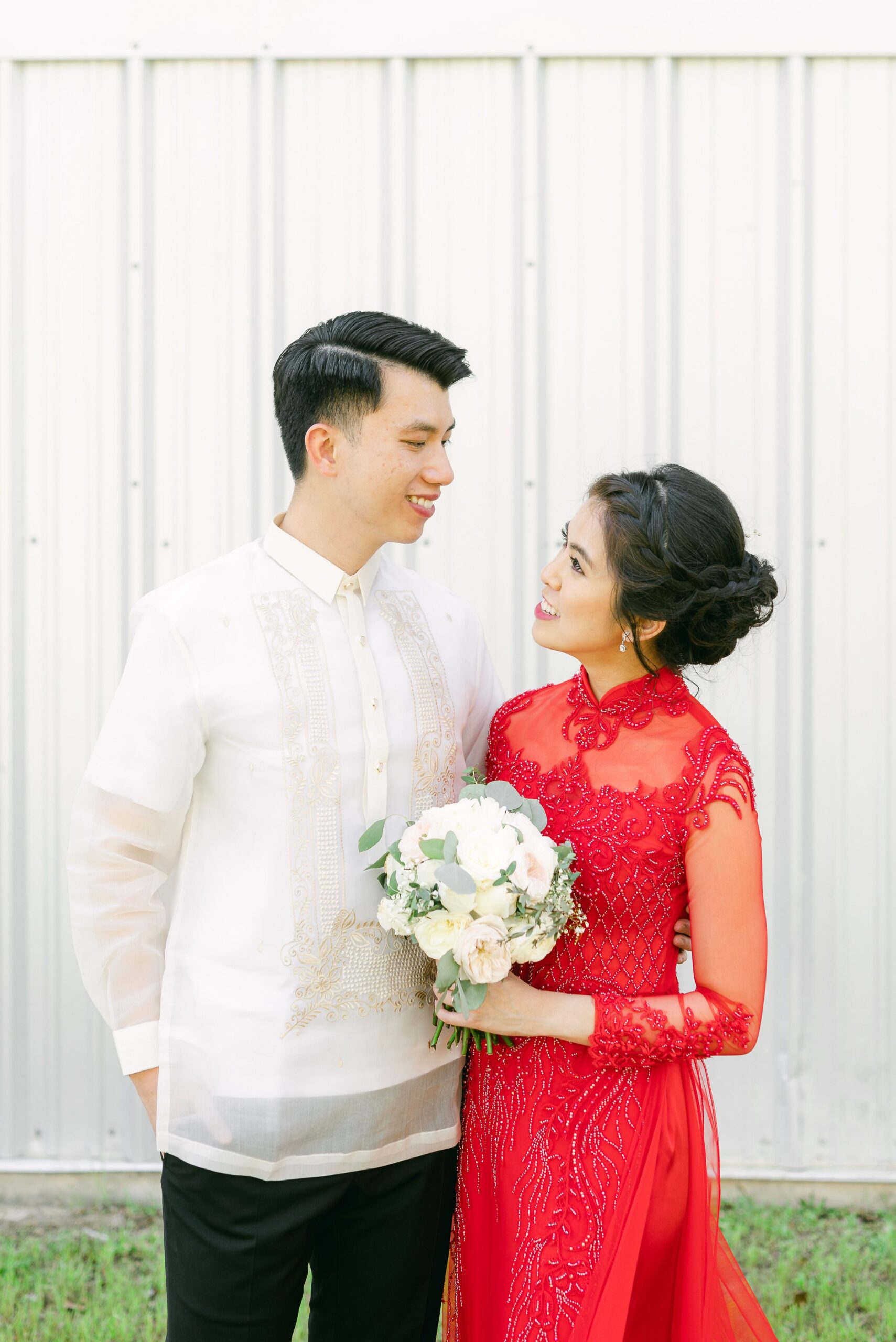 bride and groom wearing red áo dài and white barong