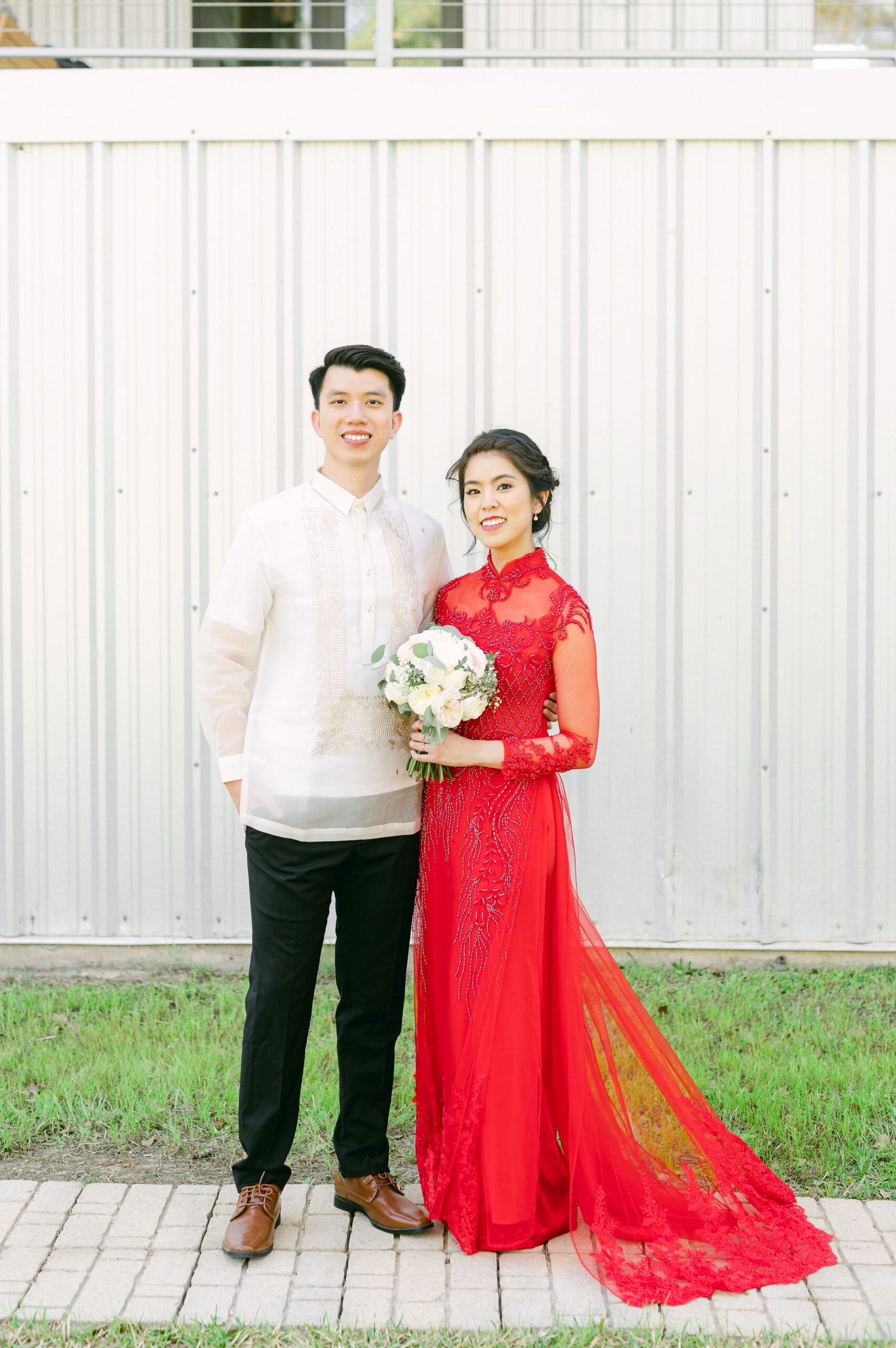 bride and groom wearing red áo dài and white barong