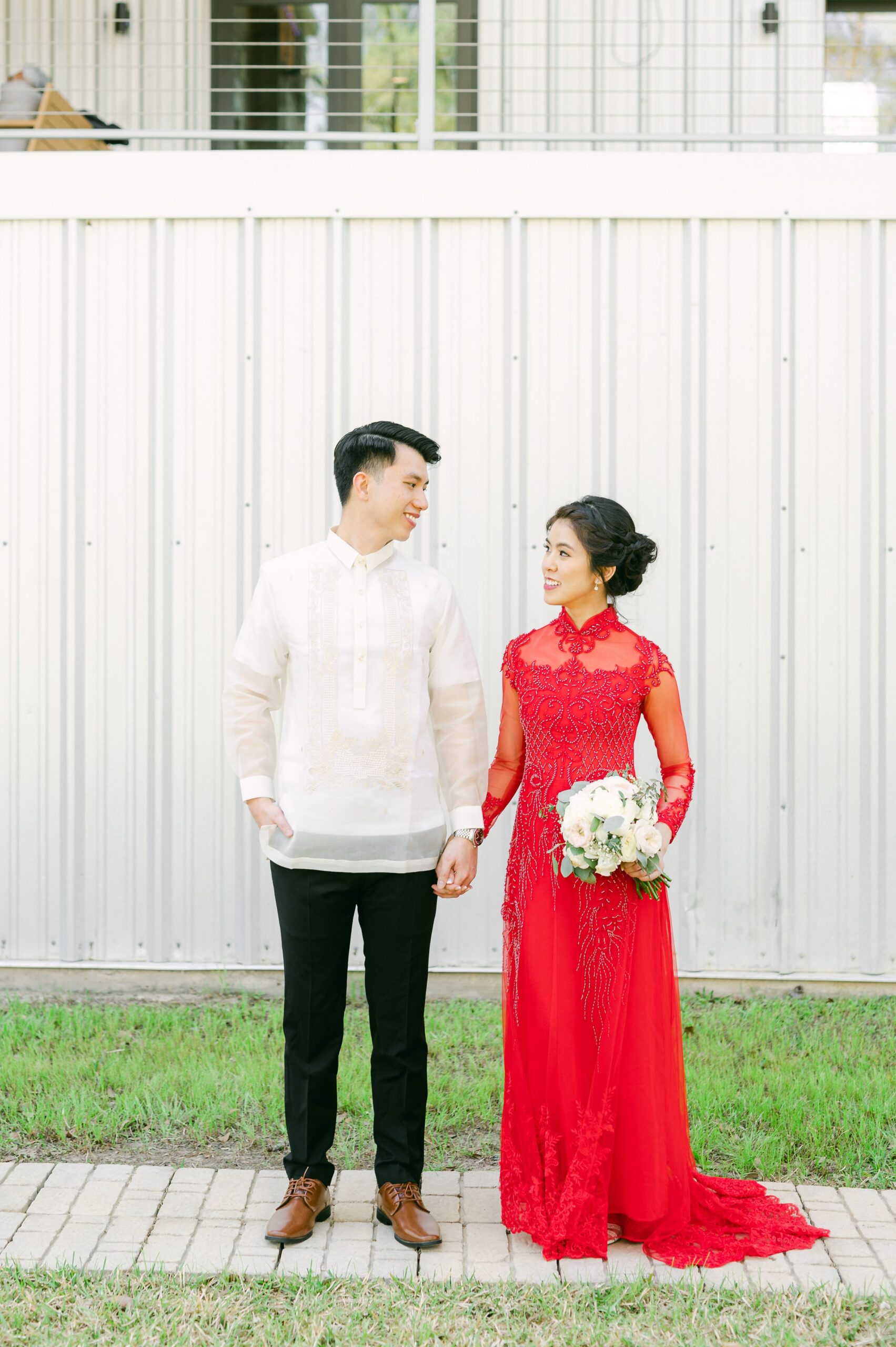 bride and groom wearing red áo dài and white barong