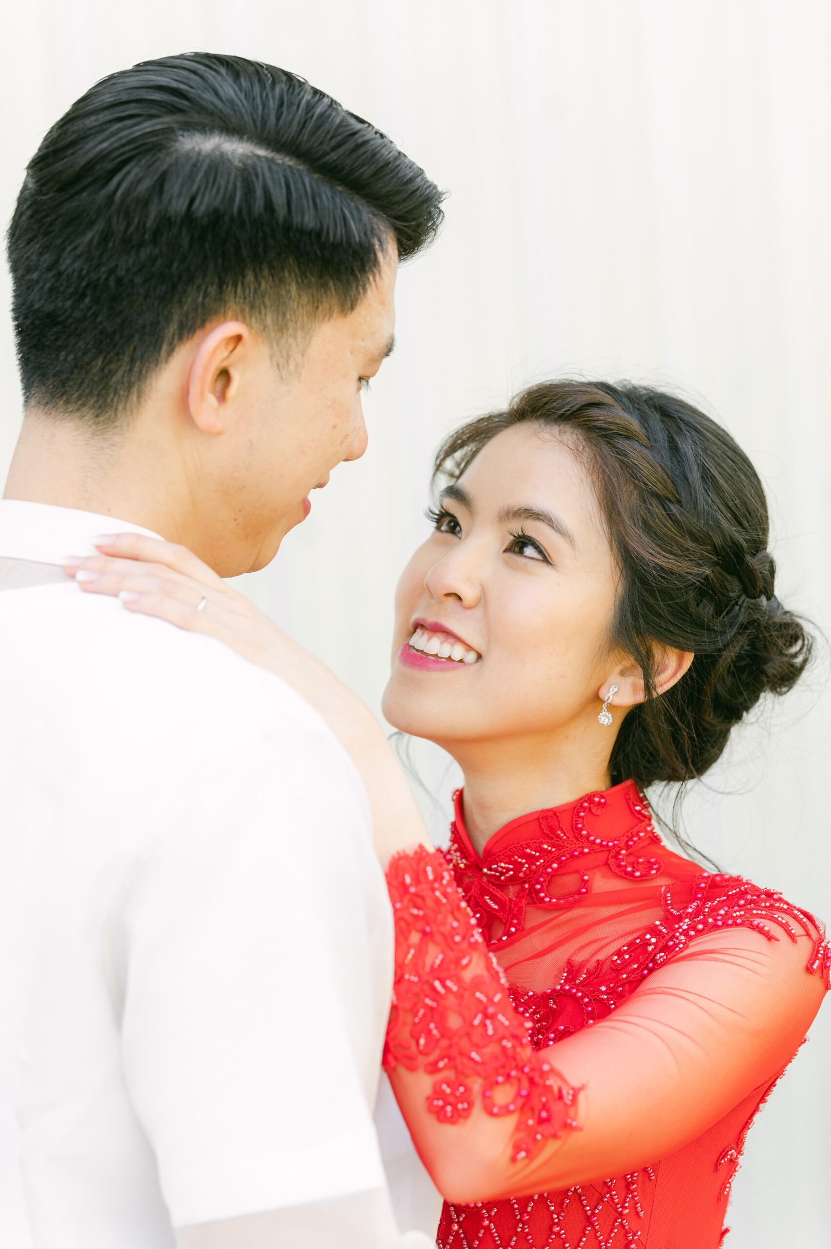 bride and groom wearing red áo dài and white barong