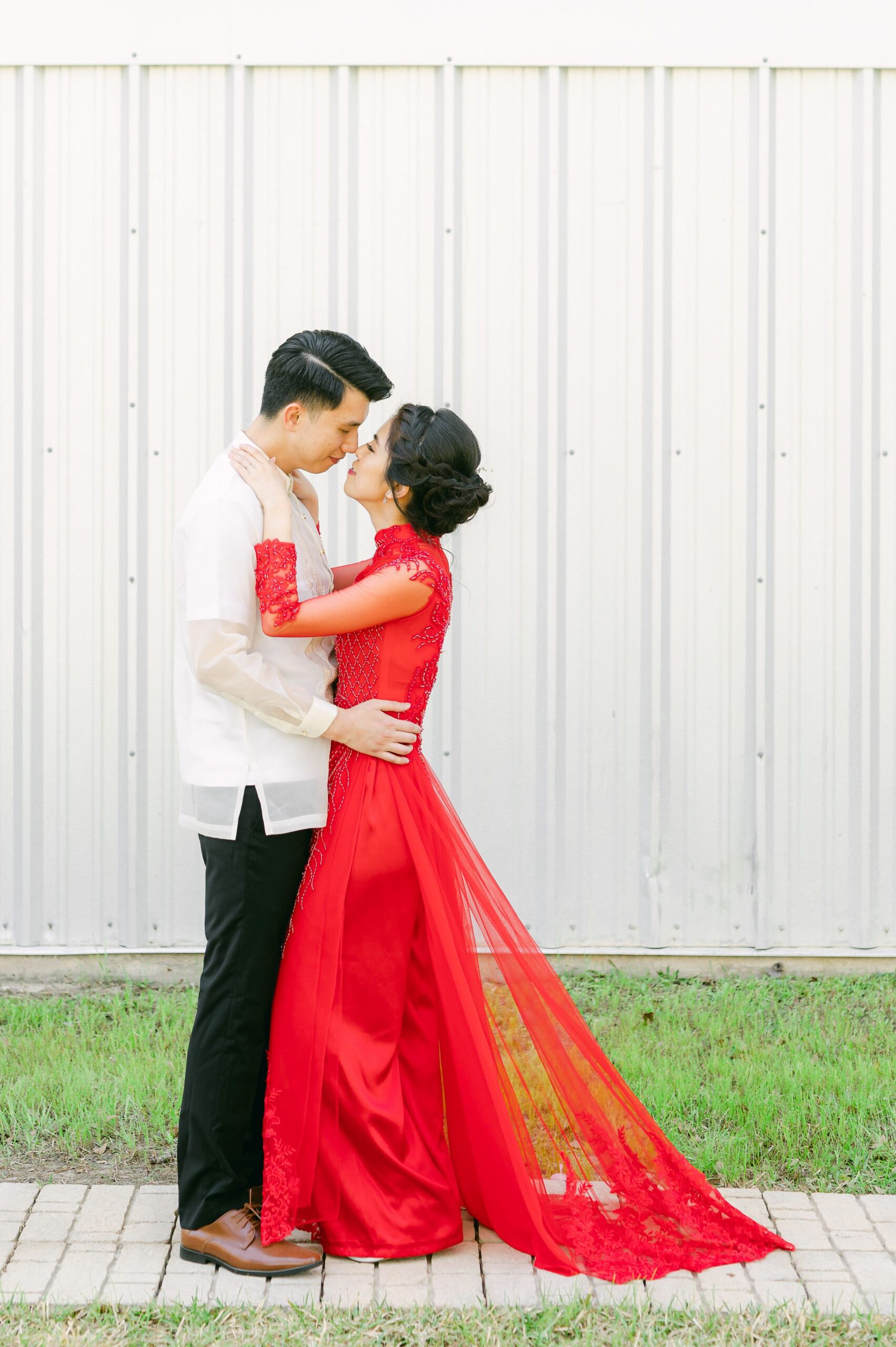 bride and groom wearing red áo dài and white barong