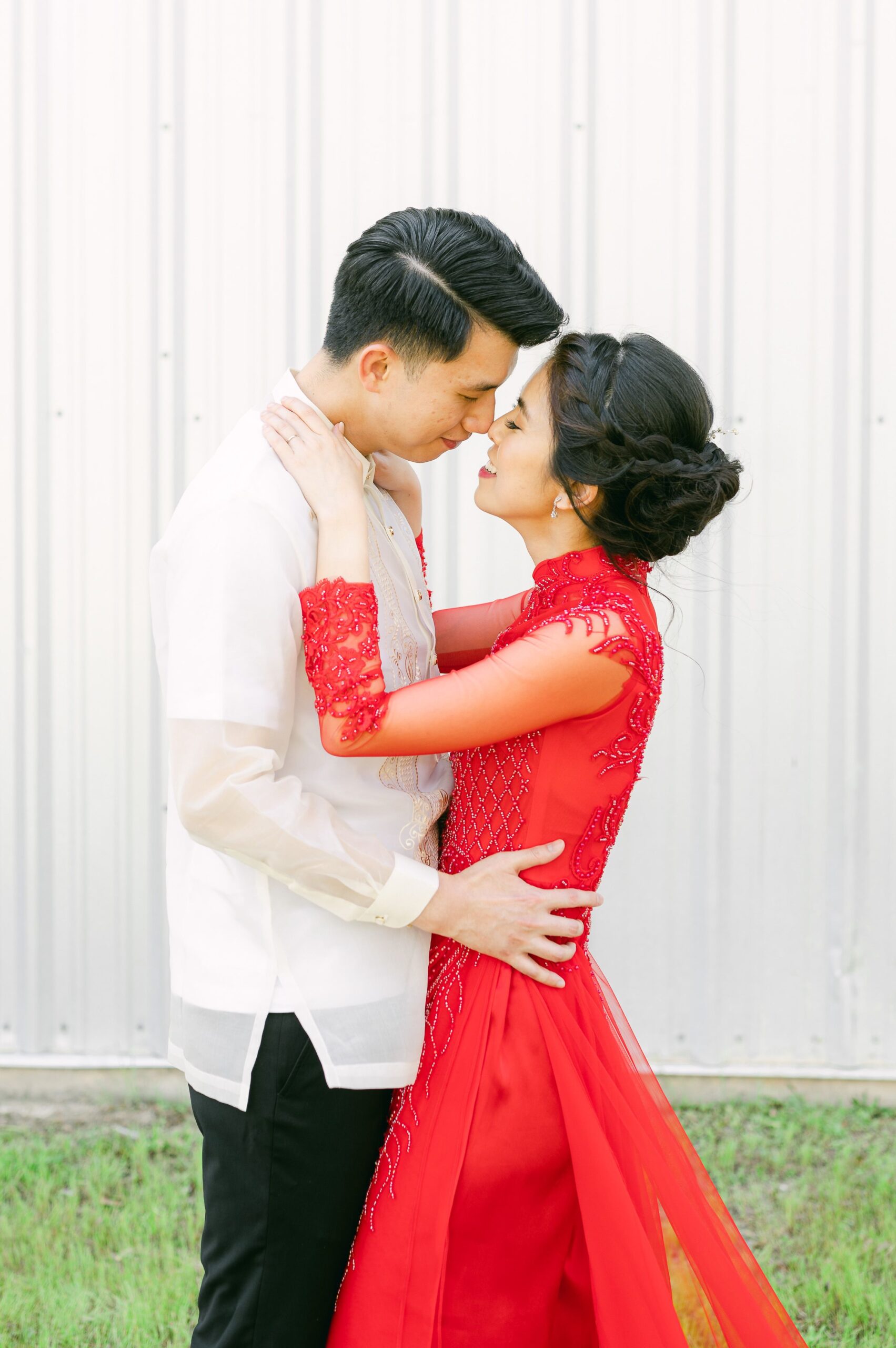 bride and groom wearing red áo dài and white barong