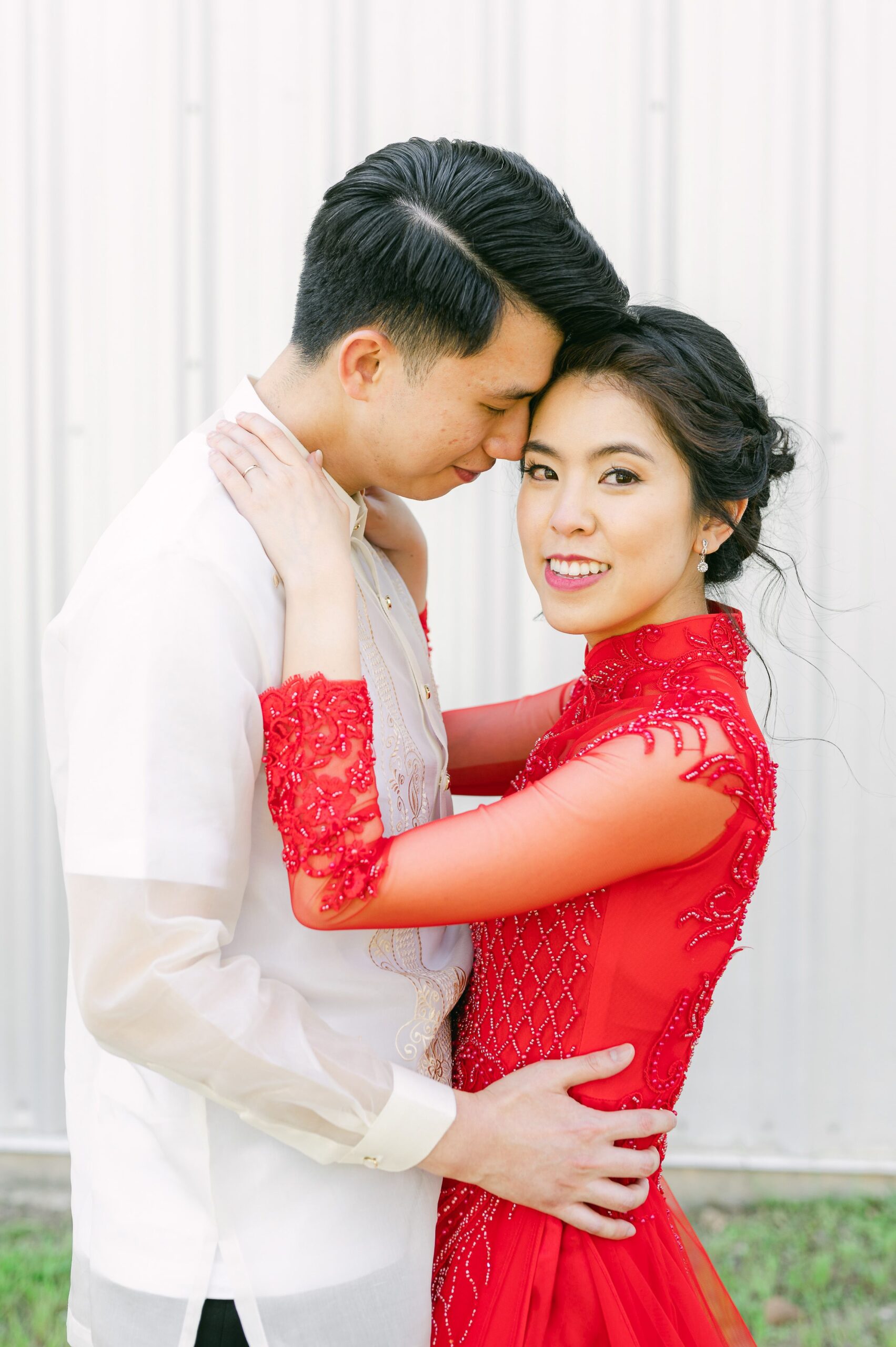 bride and groom wearing red áo dài and white barong