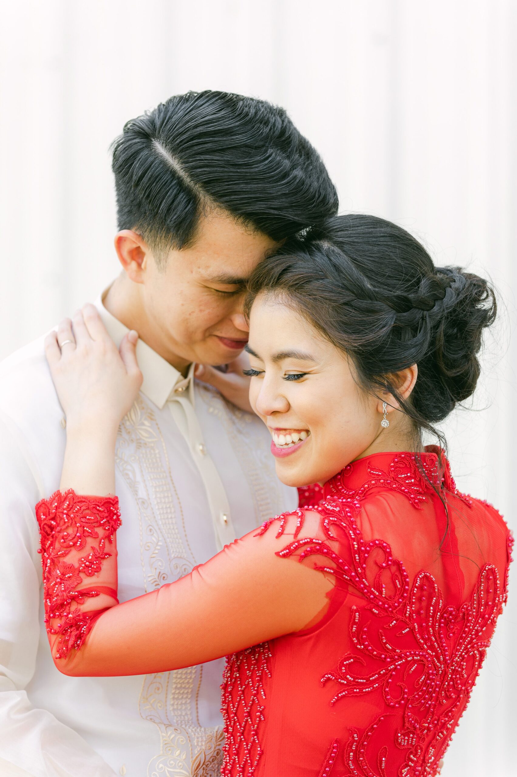 bride and groom wearing red áo dài and white barong