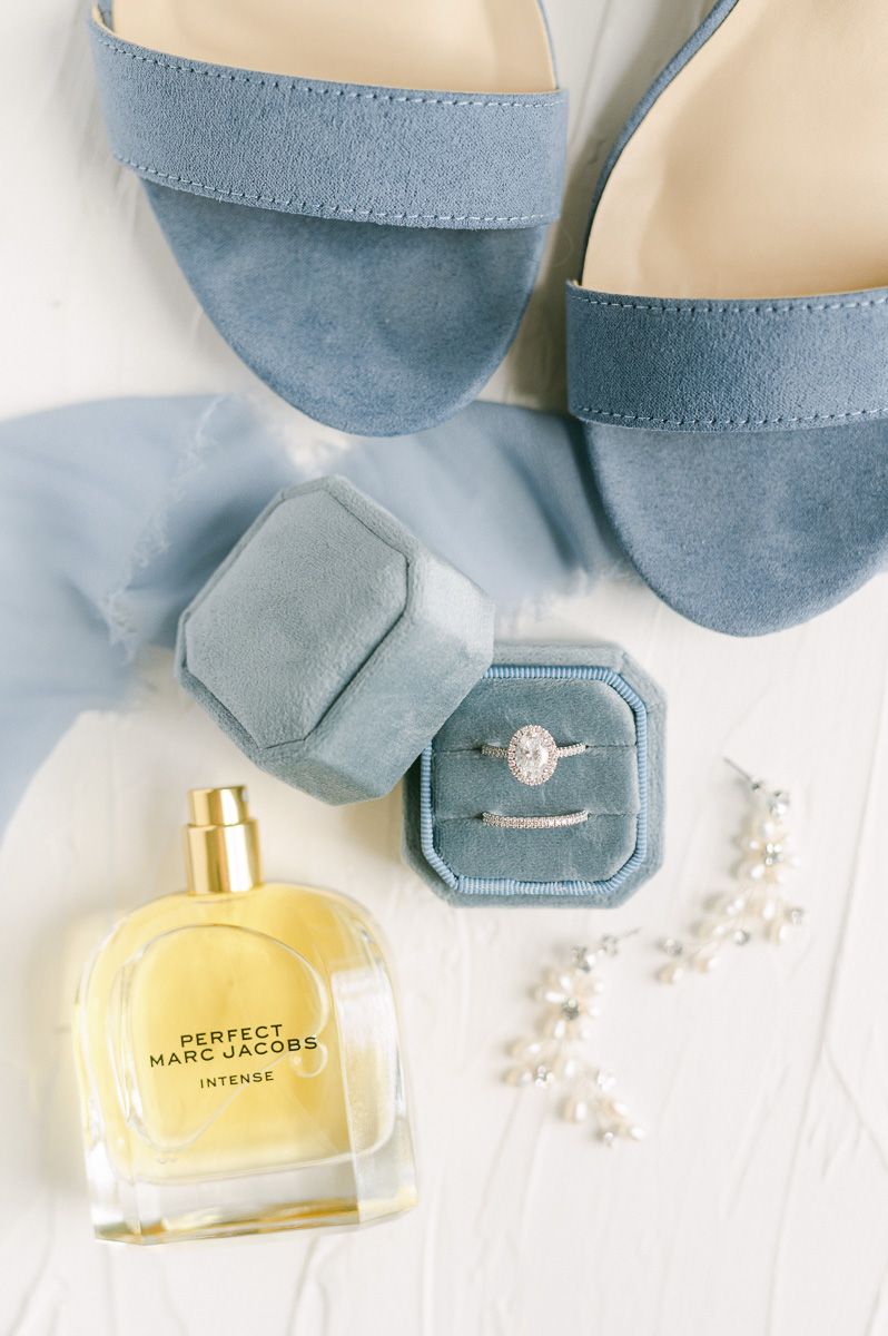wedding rings in blue ring box with perfume and shoes