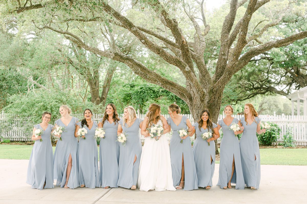 bridesmaids in blue under large tree in Pattison, Tx