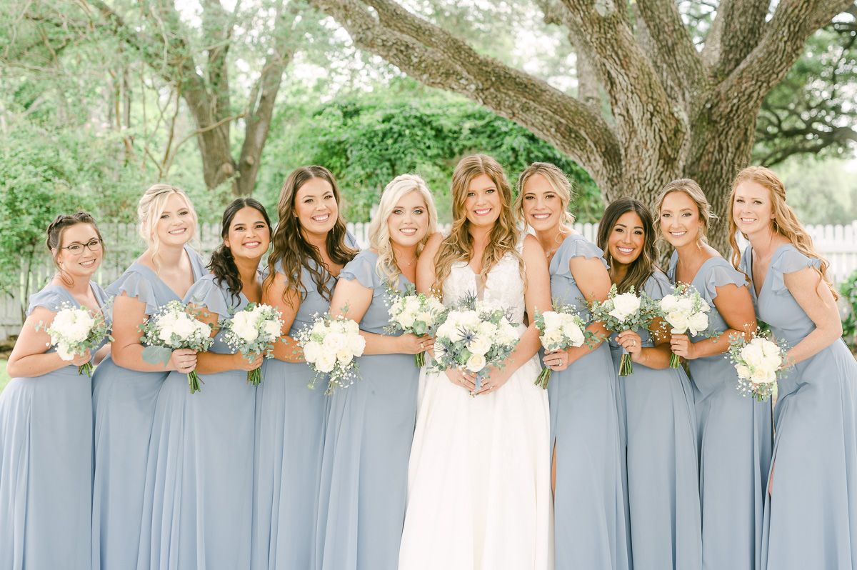 bridesmaids in blue under large tree in Pattison, Tx