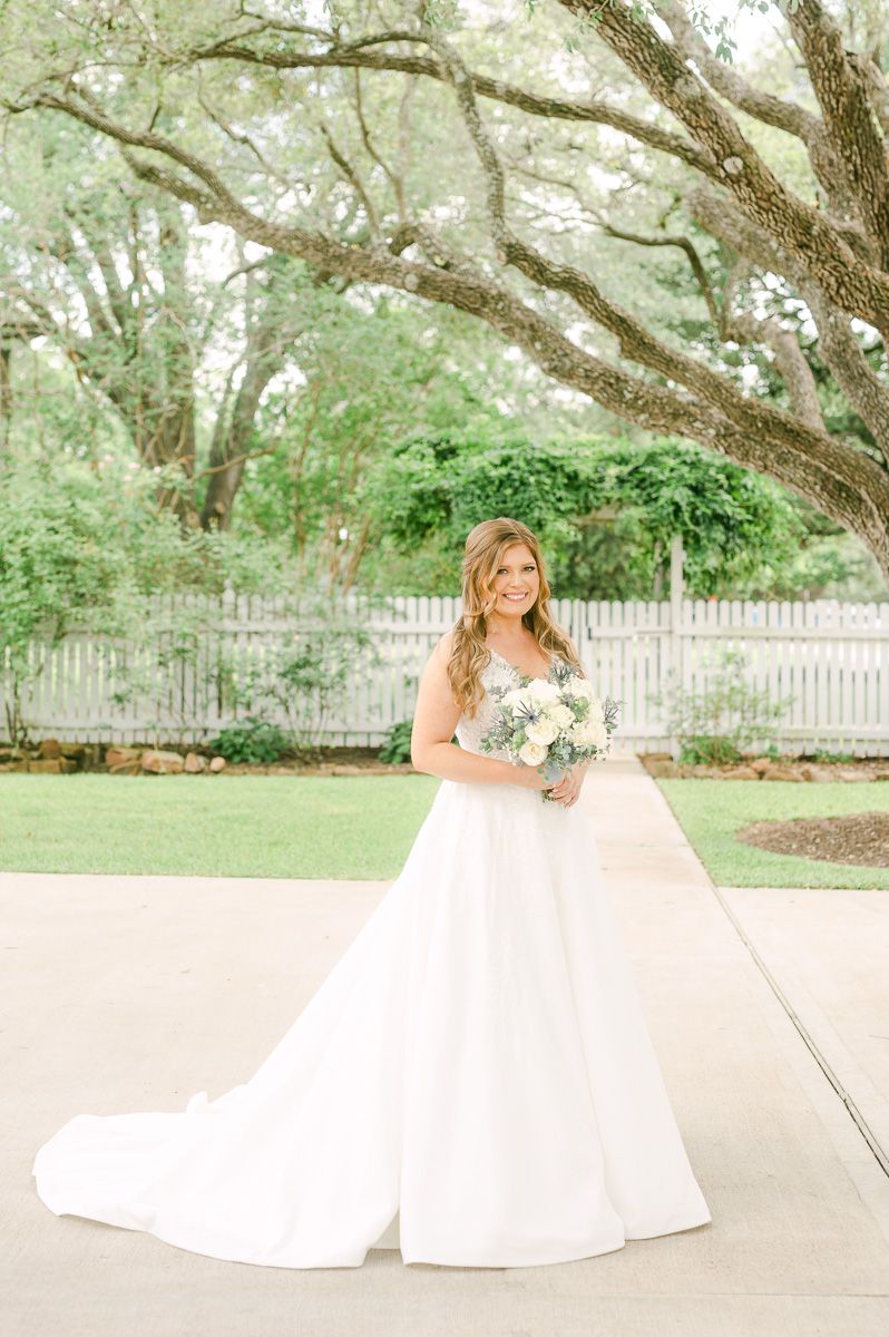 bride in blue under large tree in Pattison, Tx