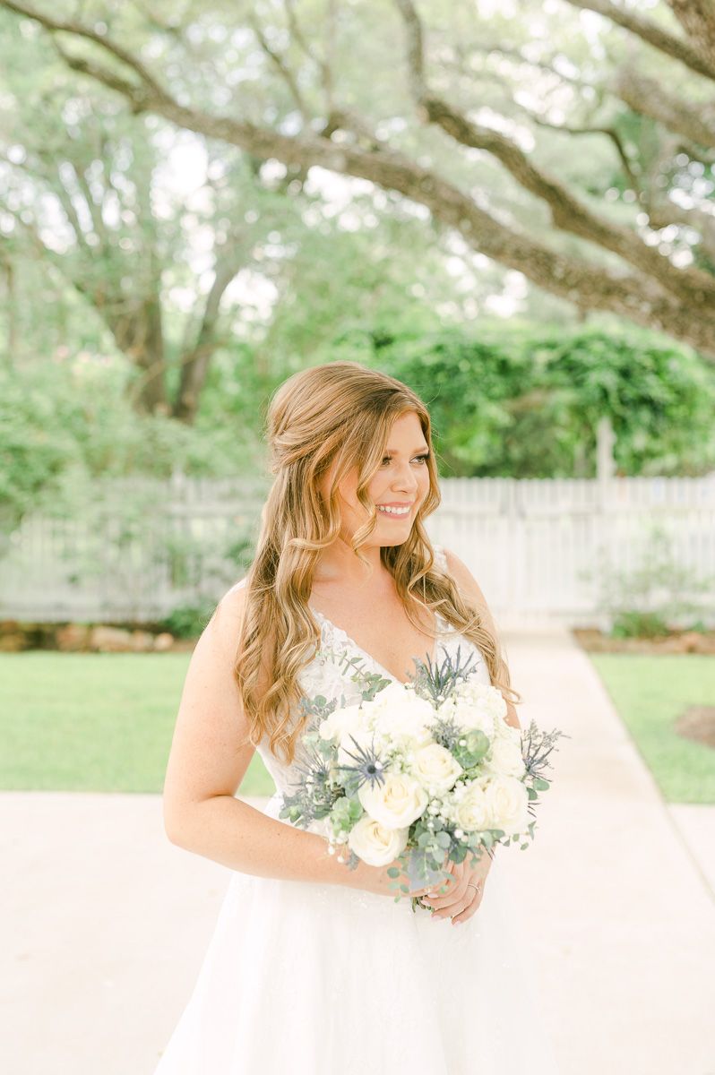 bride in blue under large tree in Pattison, Tx