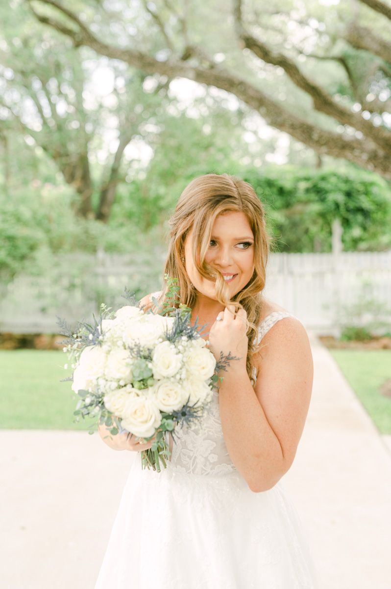 bride in blue under large tree in Pattison, Tx
