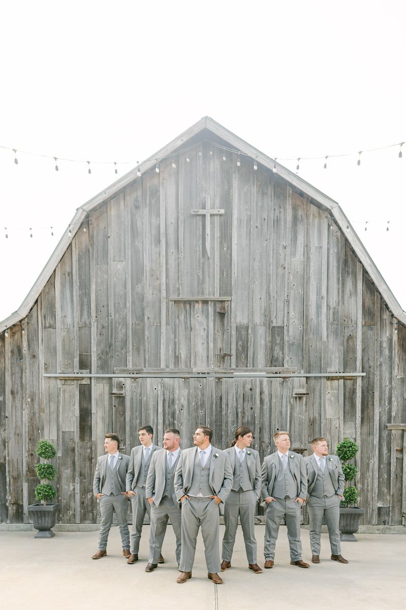 groomsmen in grey in front of old barn in Pattison, Tx
