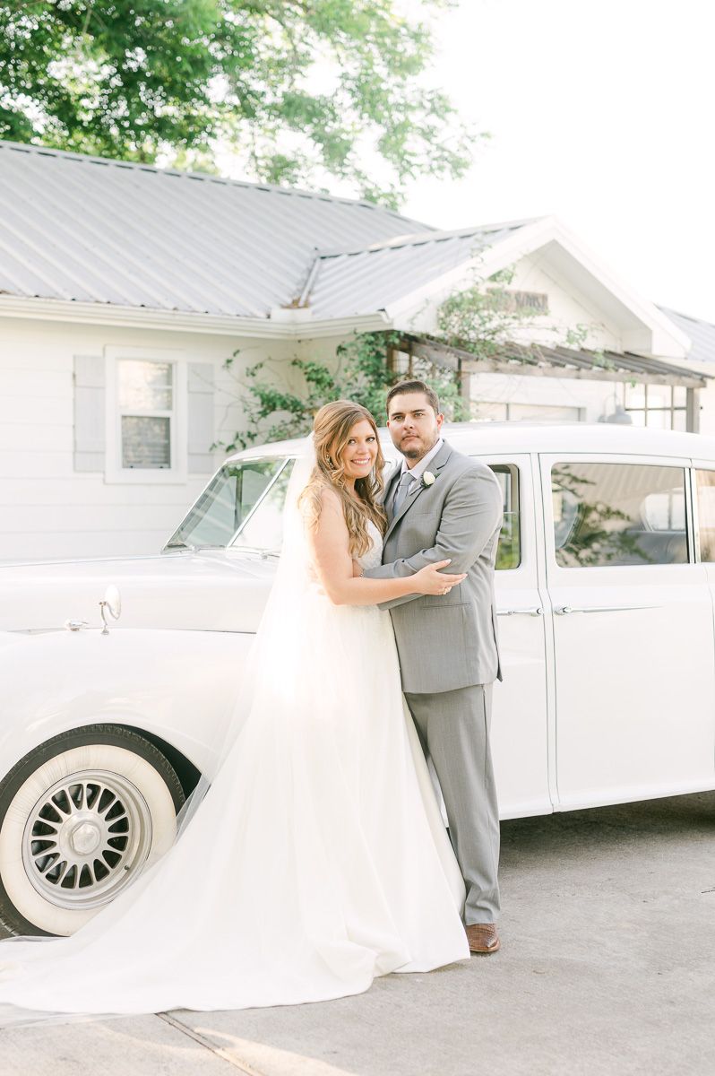 bride and groom with white classic car