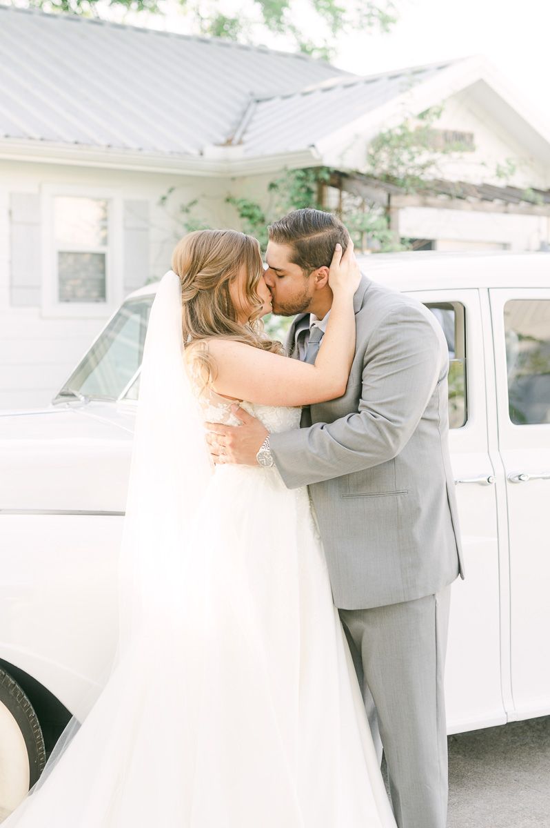 bride and groom with white classic car