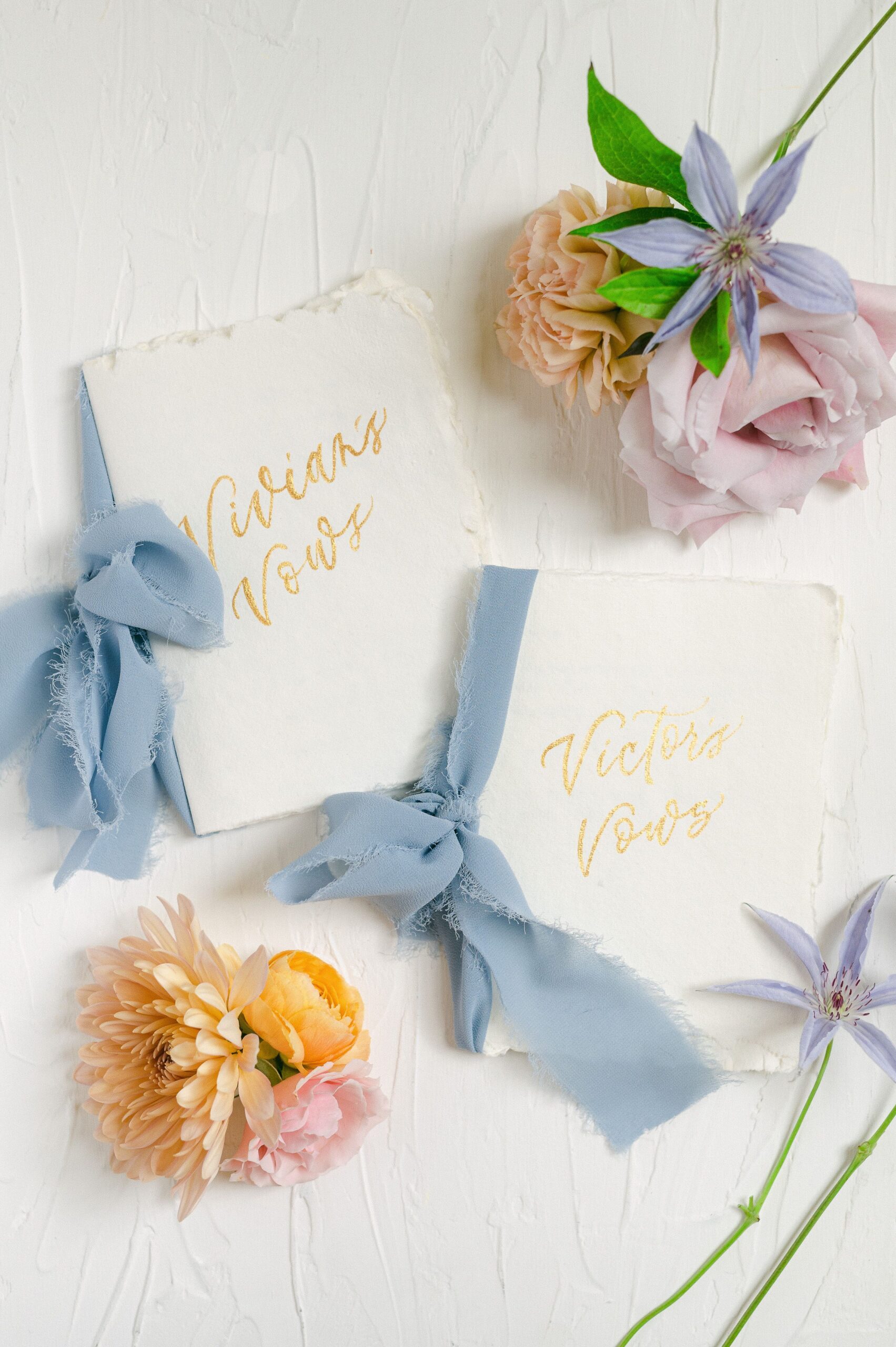 vow books with blue ribbon and colorful flowers
