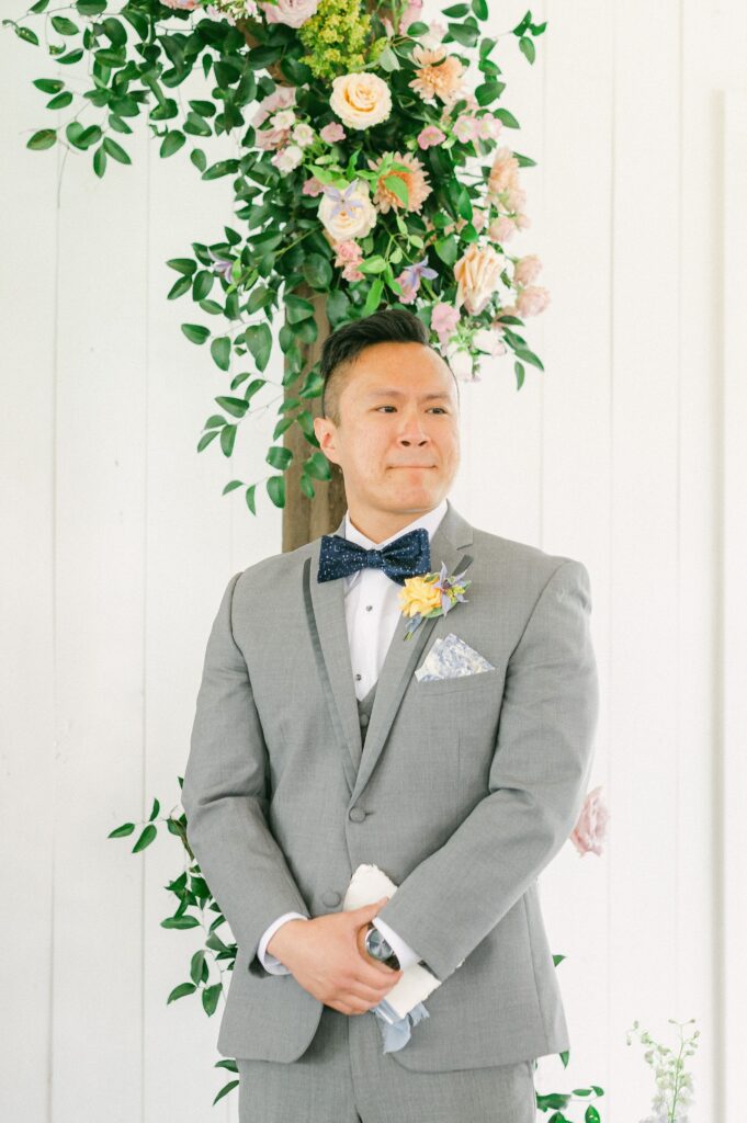 groom watching bride walk up the aisle