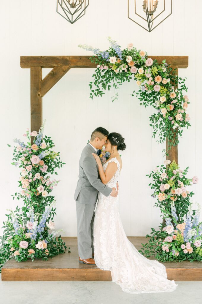 bride and groom in front of colorful wedding flowers
