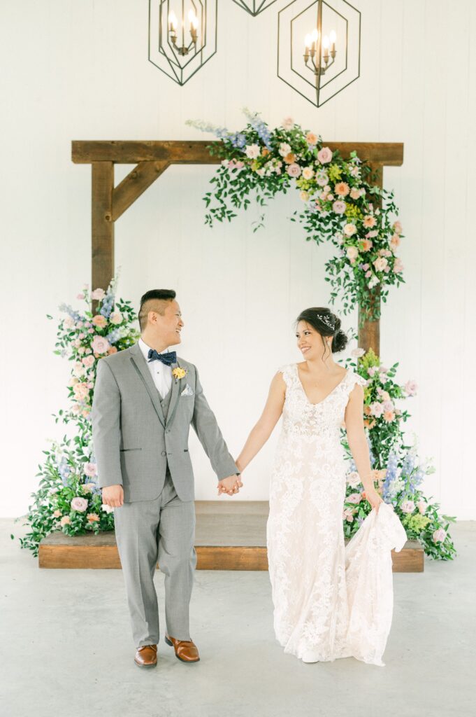 bride and groom in front of colorful wedding flowers