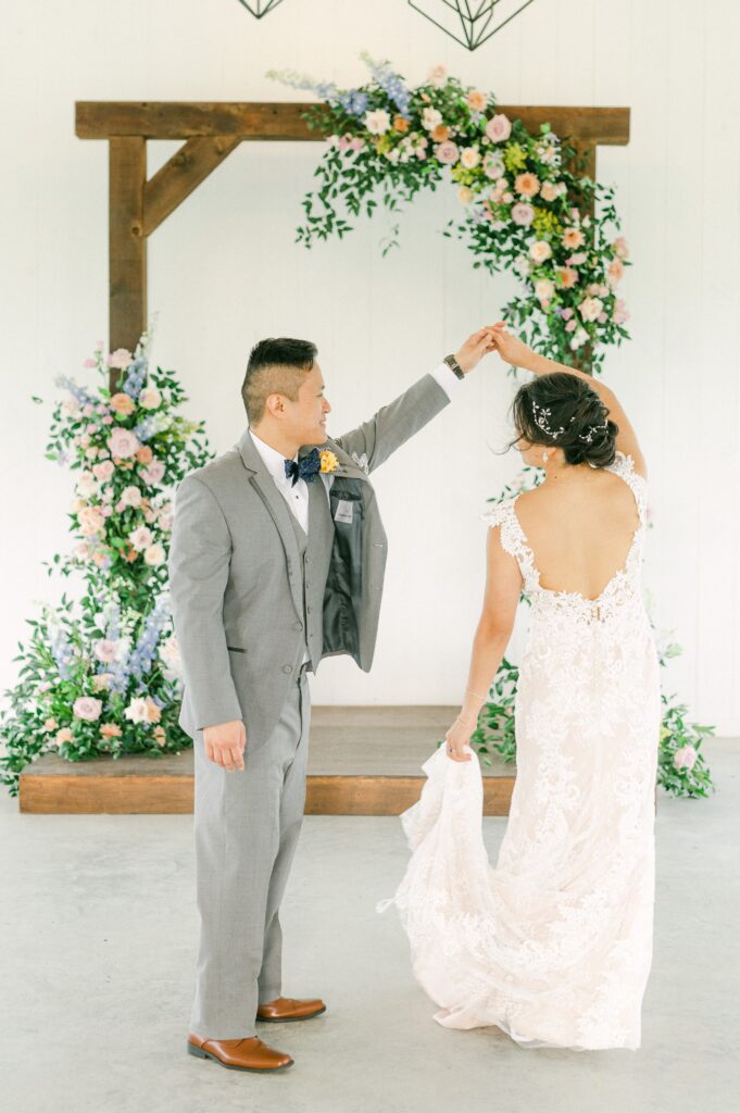 bride and groom in front of colorful wedding flowers