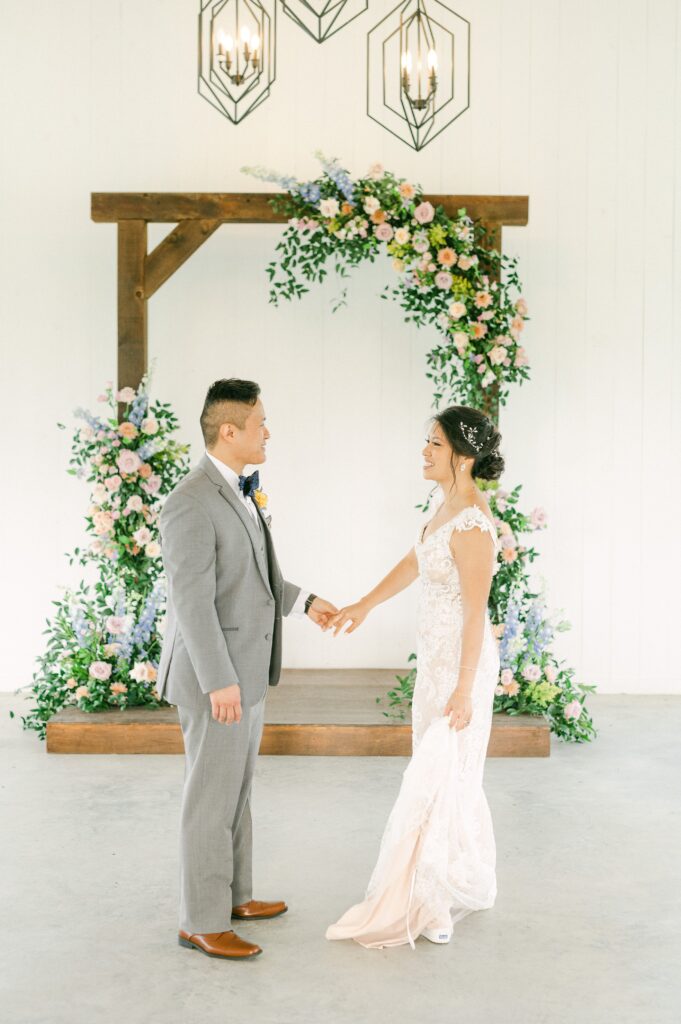 bride and groom in front of colorful wedding flowers