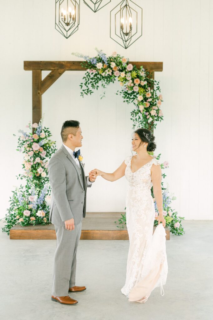 bride and groom in front of colorful wedding flowers