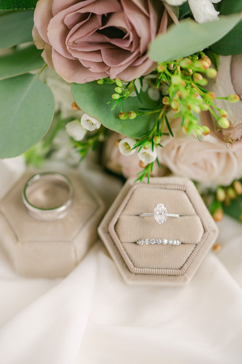 wedding rings in cream ring box with flowers