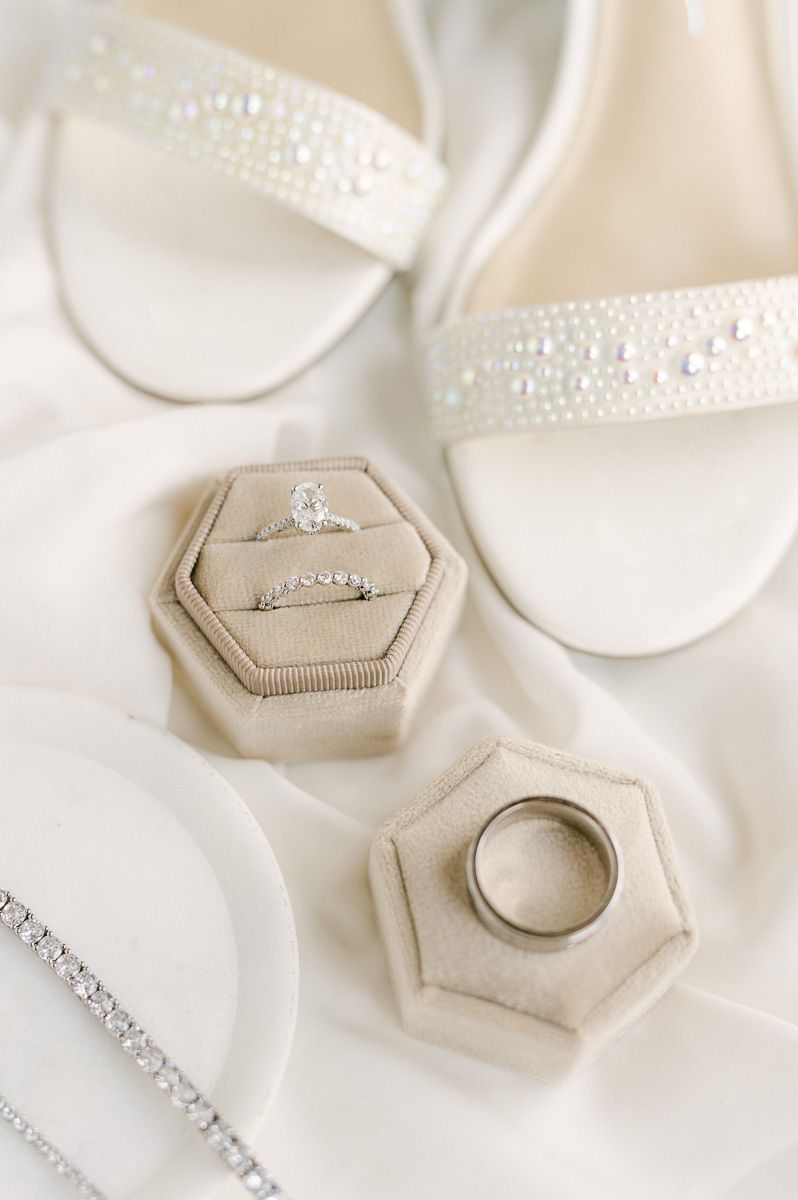 wedding rings in cream ring box with bride's shoes
