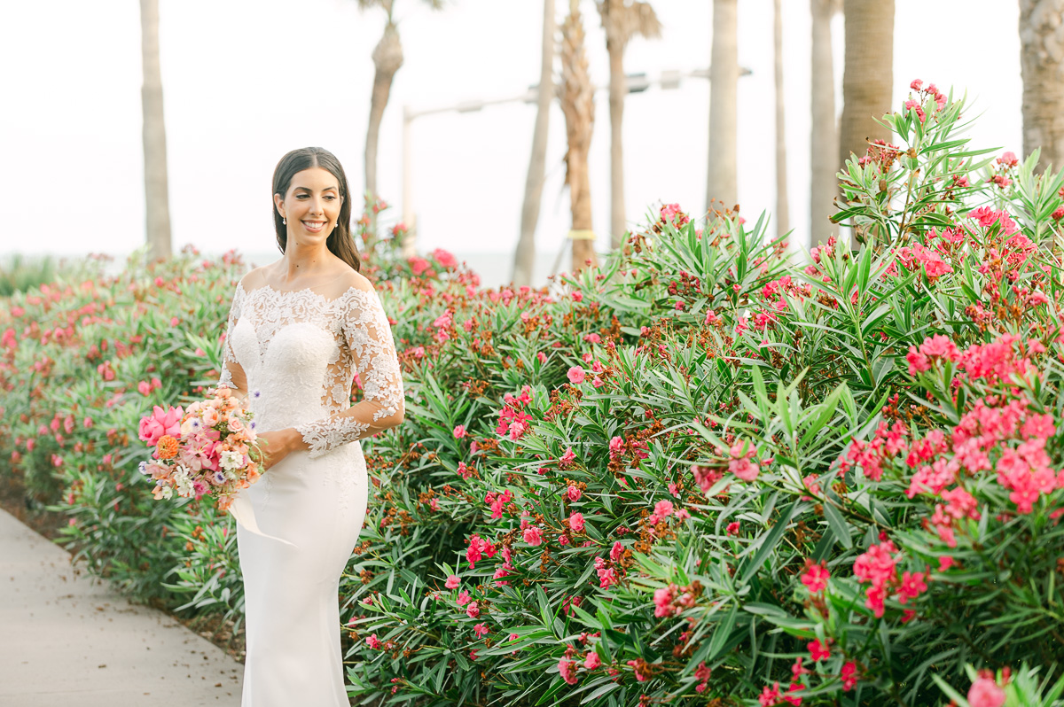 a bride near a pink flower bush in galveston
