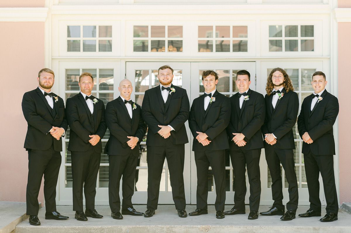 groomsmen in black suits at Grand Galvez
