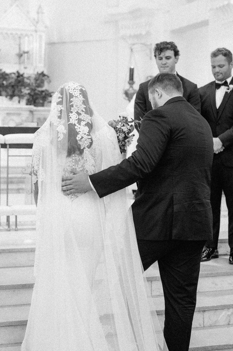 groom helping his bride up the alter