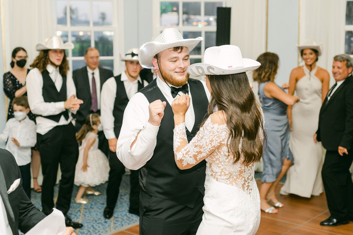 couple dancing at wedding reception wearing cowboy hats