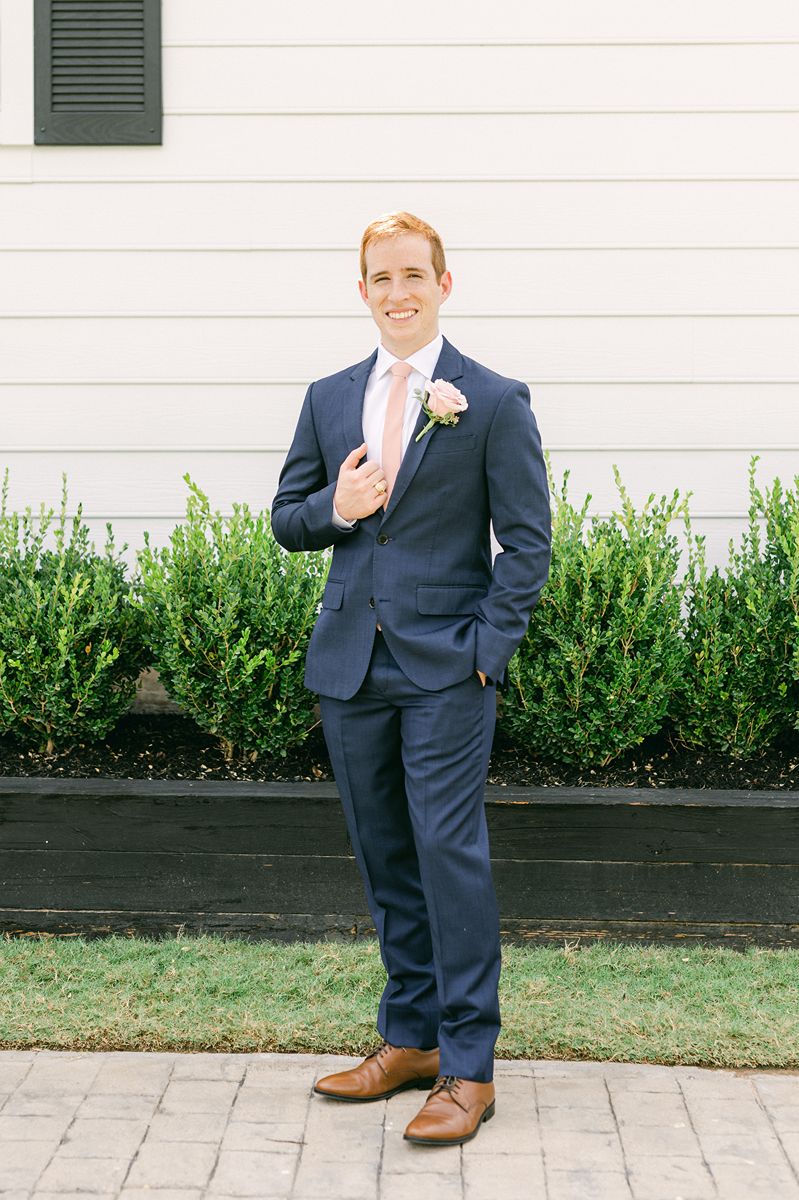 groom in navy blue with pink tie
