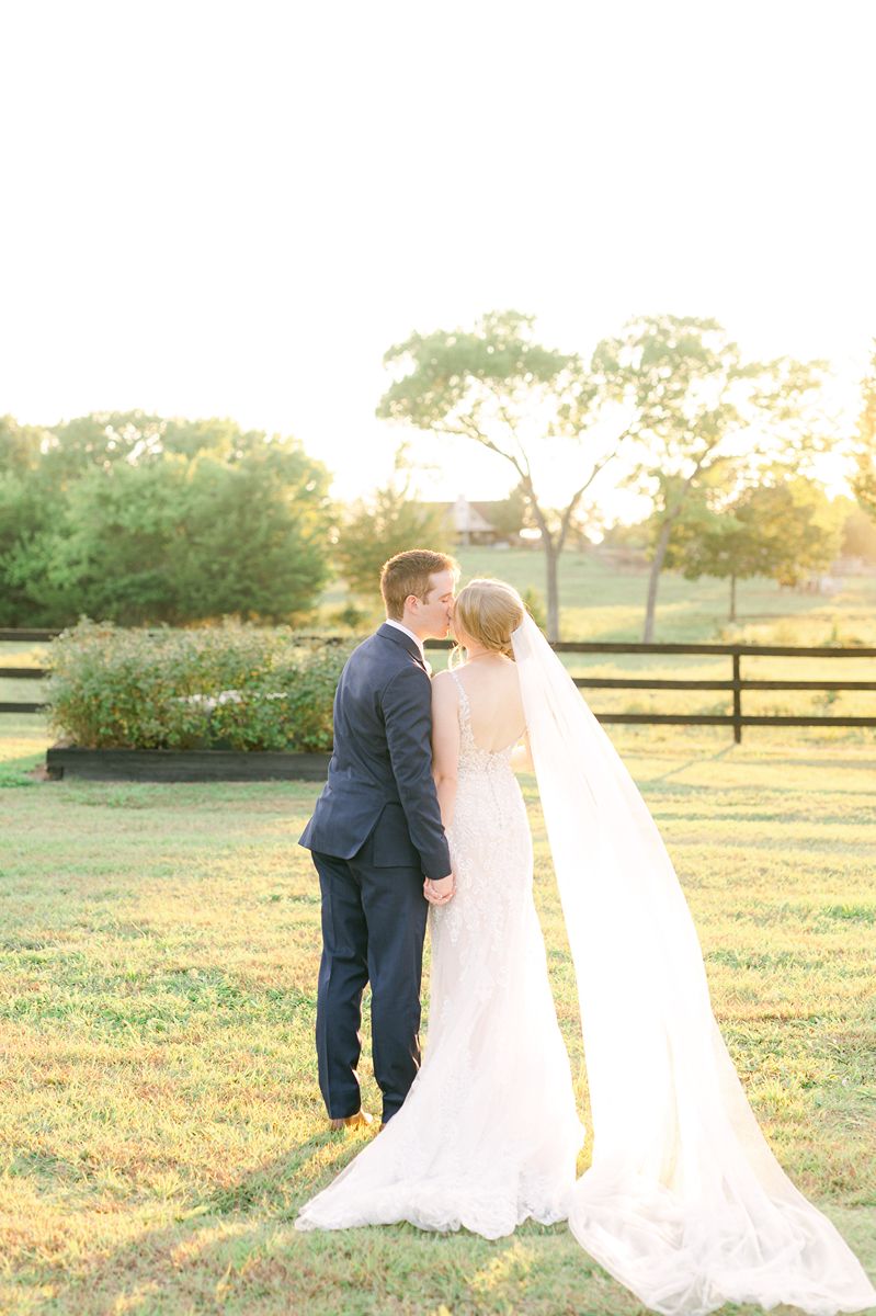 bride and groom kissing during golden hour