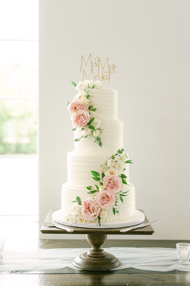 wedding cake with pink flowers and greenery at Venue 311 Plantersville Tx