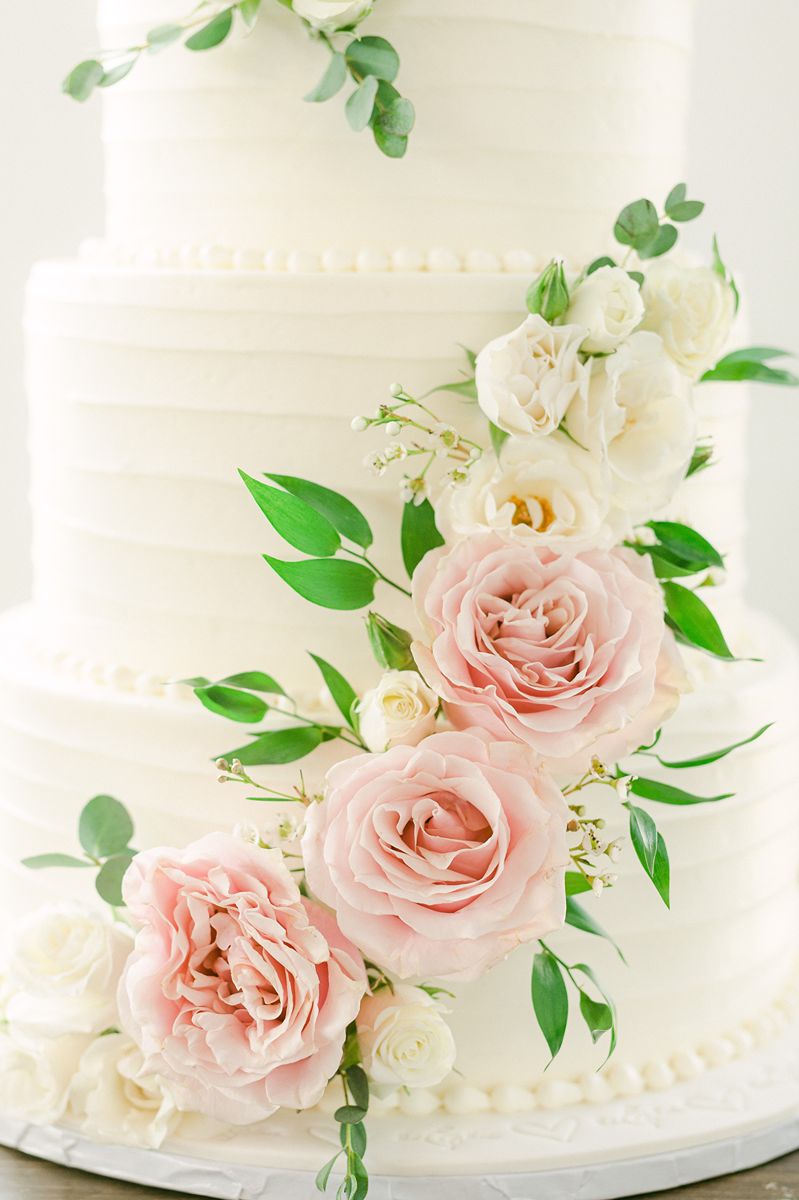 wedding cake with pink flowers and greenery at Venue 311 Plantersville Tx