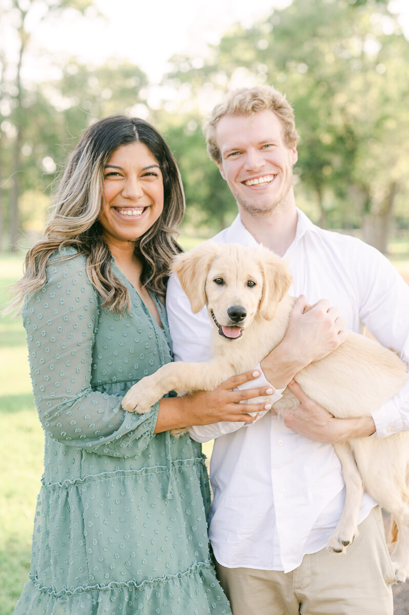 couple with their puppy at their engagement session with houston wedding photographer