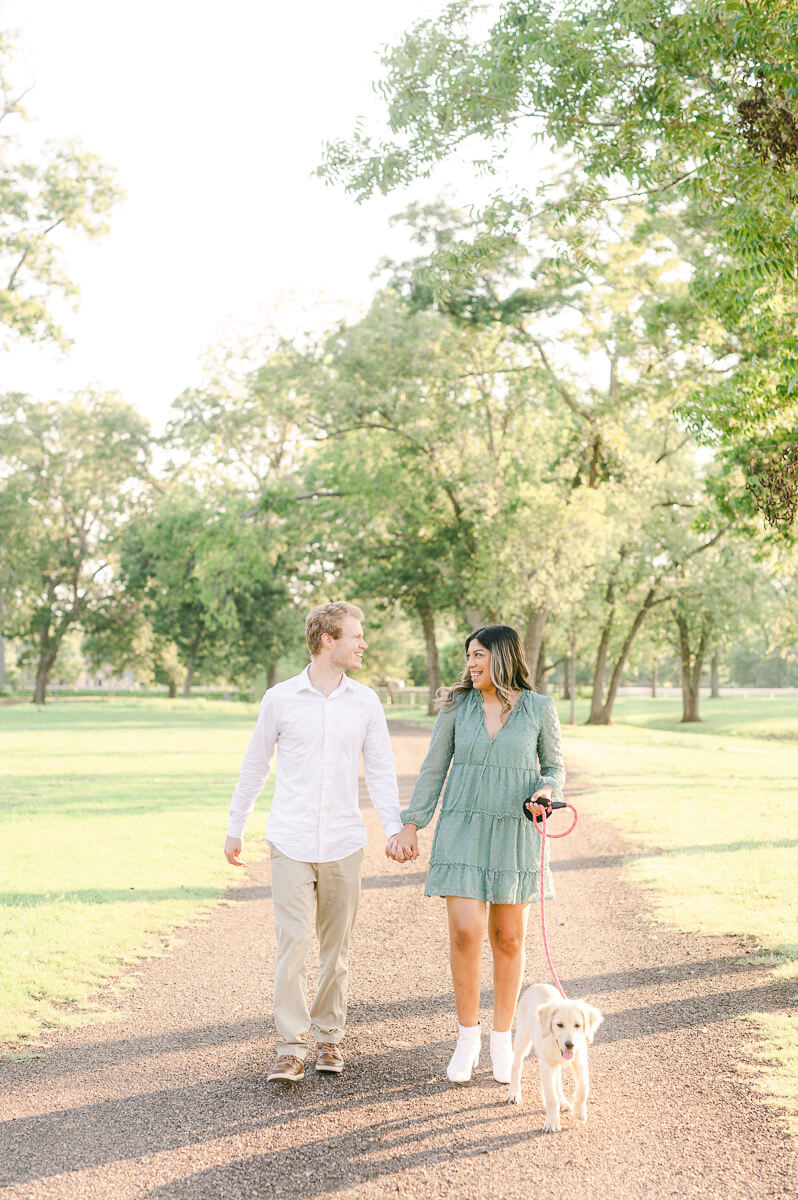 couple walking their golden retriever puppy in houston