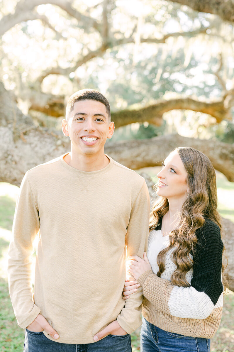 a couple standing in front of a Spanish moss tree