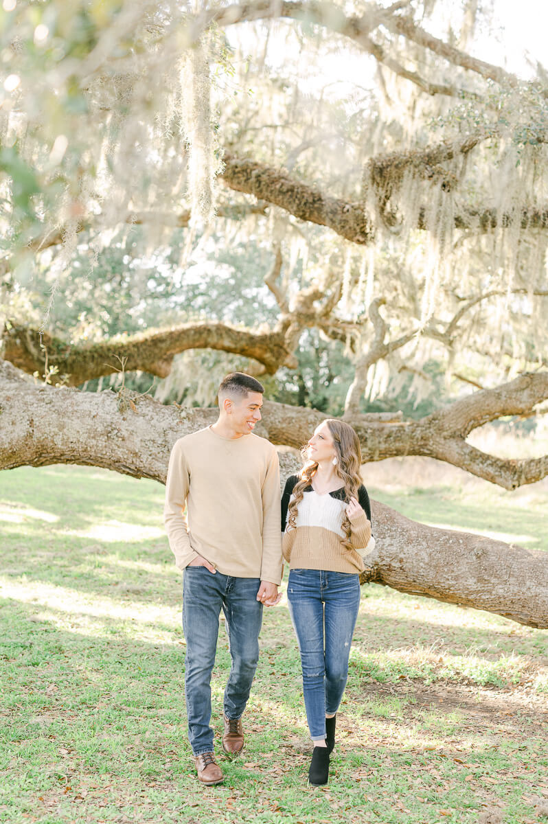 a couple standing in front of a Spanish moss tree at brazos bend state park