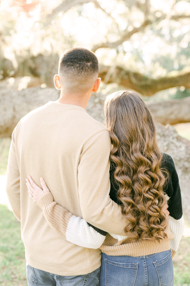 a couple standing in front of a Spanish moss tree at brazos bend state park