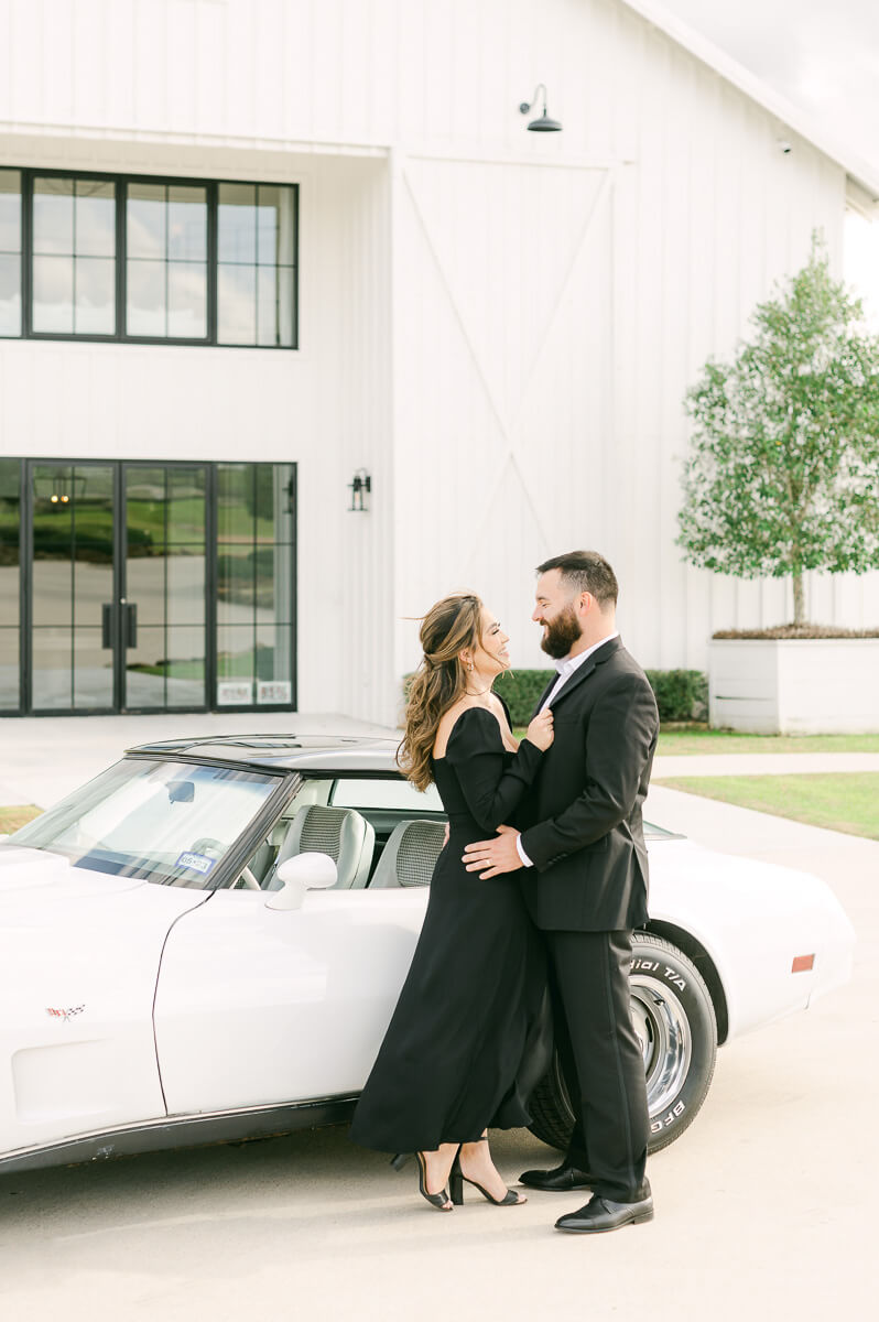 couple at the farmhouse wedding venue with vintage car