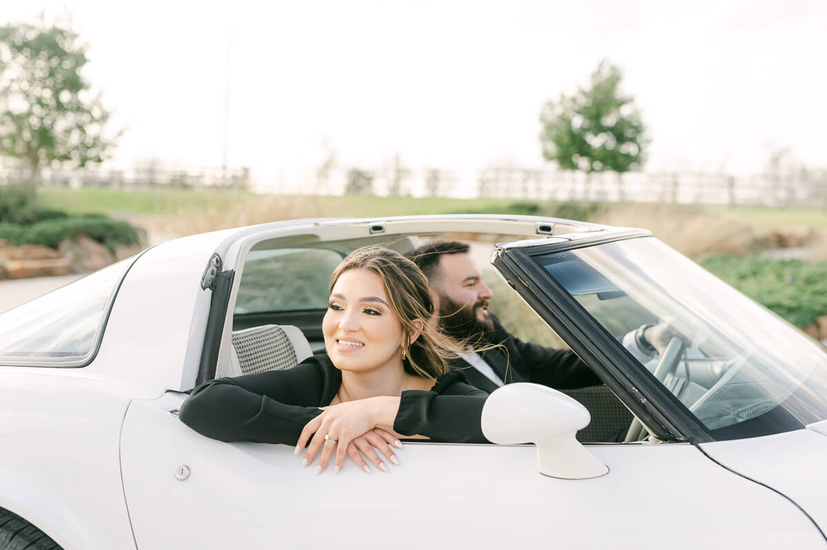 couple at the farmhouse wedding venue with vintage car