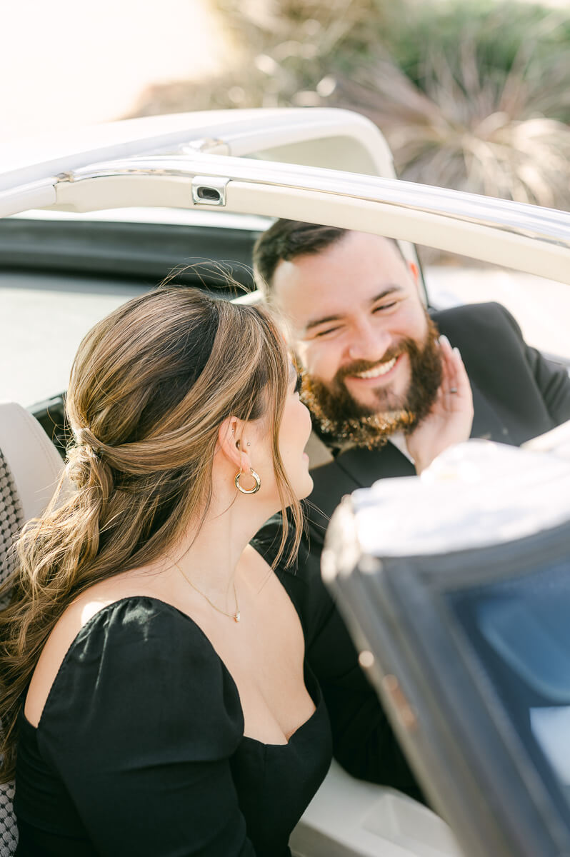 couple at the farmhouse wedding venue with vintage car