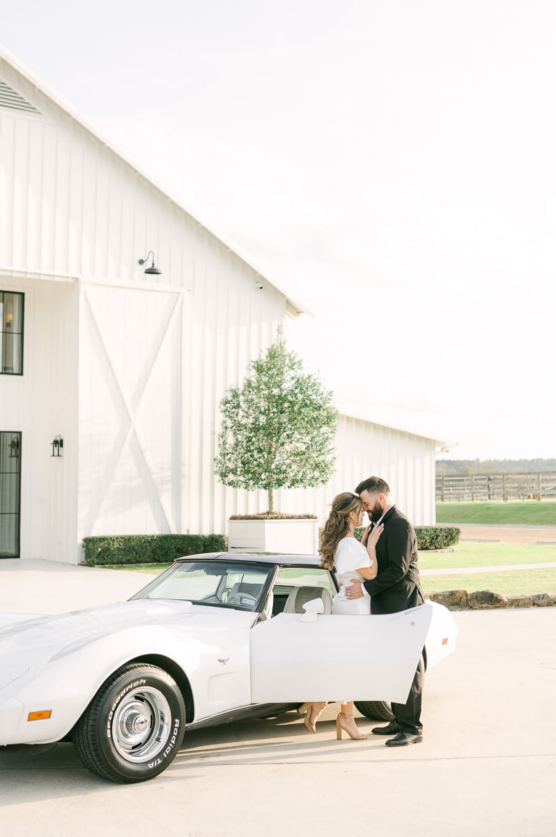 couple with white vintage car at the farmhouse