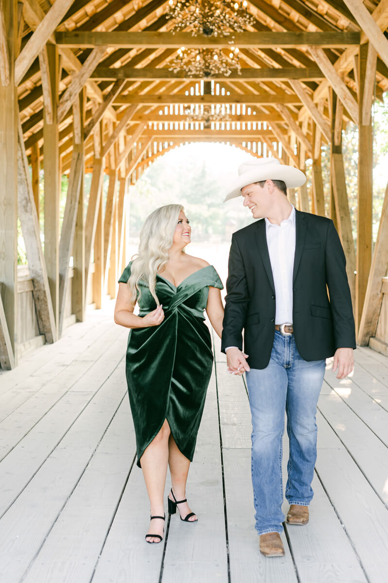 a couple walking on the bridge outside big sky barn