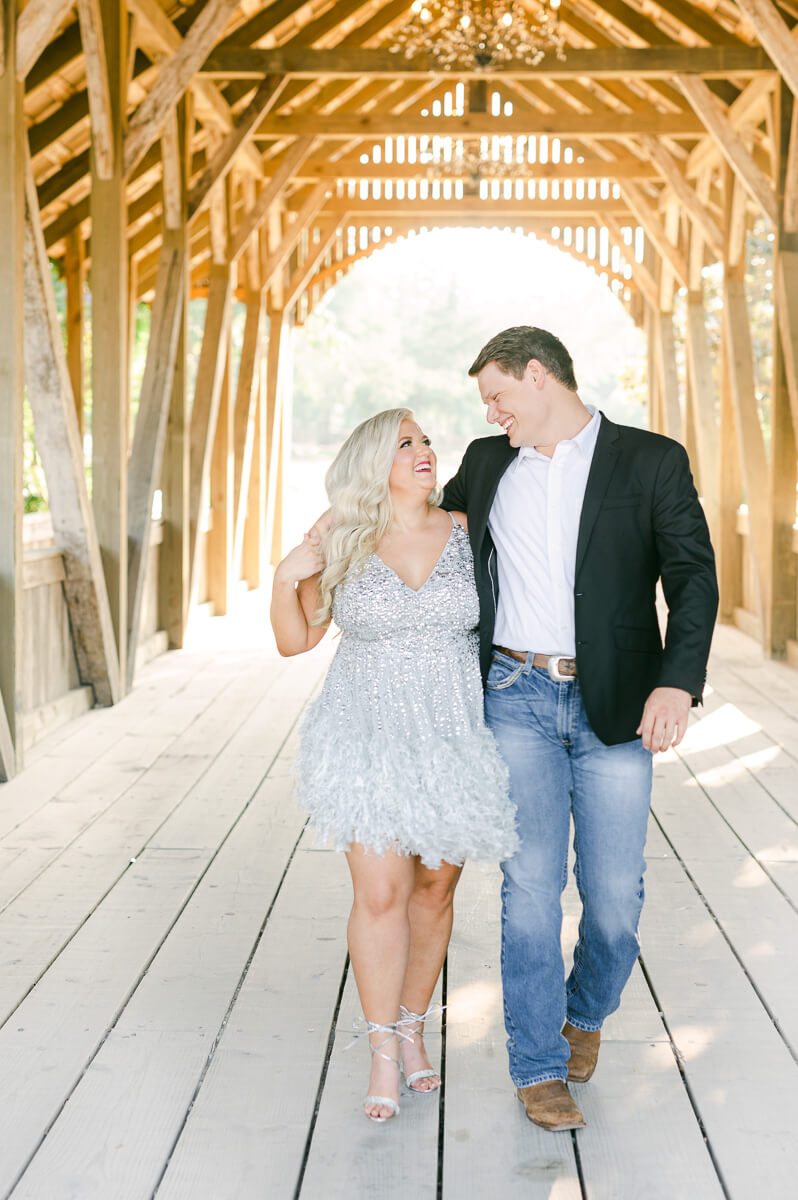 a couple walking on the bridge outside big sky barn