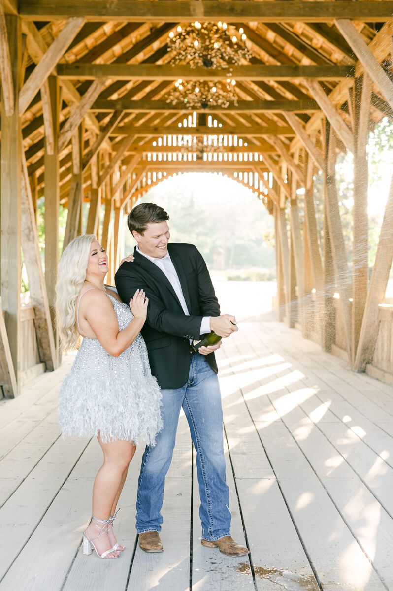 a couple popping champagne at big sky barn 